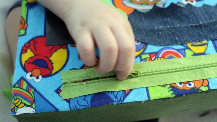 This DIY sensory board is so DOABLE and easy to make! You don't need tools or special equipment and it is full of toddler activities to develop fine motor skills, sensory play, and to teach colors, shapes, alphabet, and more!