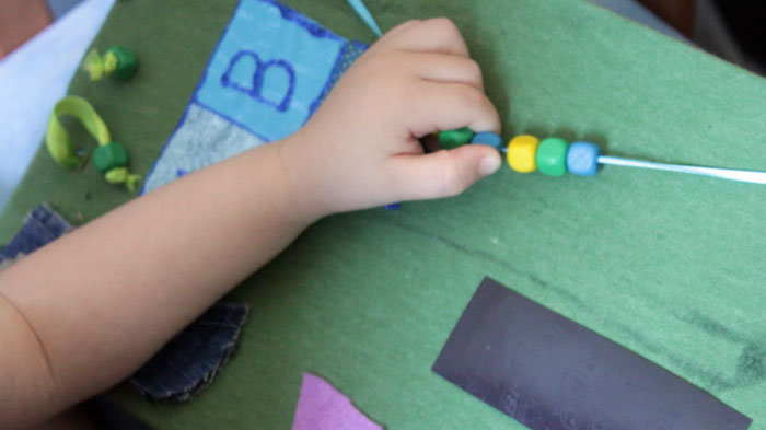 This DIY sensory board is so DOABLE and easy to make! You don't need tools or special equipment and it is full of toddler activities to develop fine motor skills, sensory play, and to teach colors, shapes, alphabet, and more!