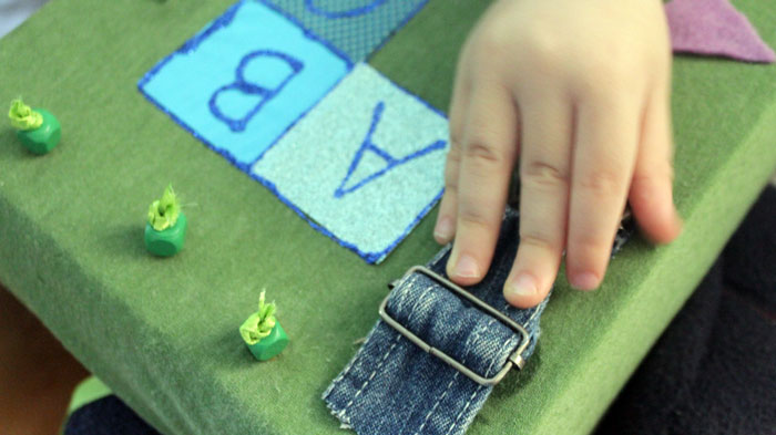 This DIY sensory board is so DOABLE and easy to make! You don't need tools or special equipment and it is full of toddler activities to develop fine motor skills, sensory play, and to teach colors, shapes, alphabet, and more!