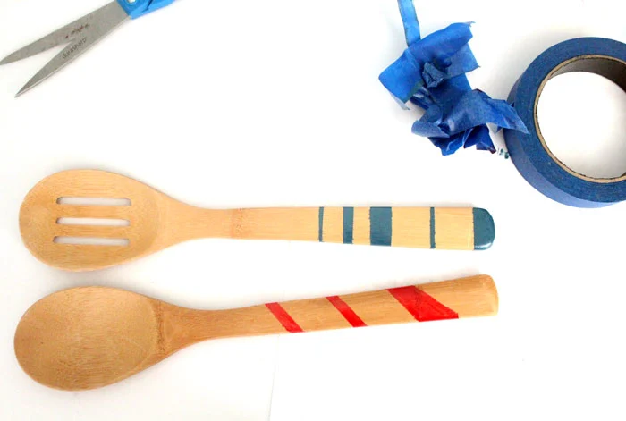 Click to find out the surprising material used to paint these wooden spoons! Painted wooden spoons are a great cheap DIY gift and easy craft. These are striped and durable - perfect for kitchen decor or cooking.