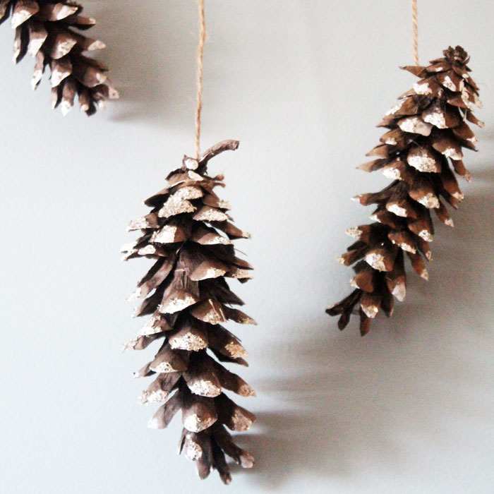 Make this beautiful snowy pine cone wall hanging! Such a pretty and easy winter craft to decorate your home. Plus, how to add a matching aroma to your decor!