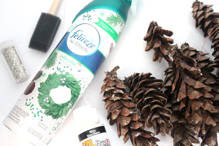 Make this beautiful snowy pine cone wall hanging! Such a pretty and easy winter craft to decorate your home. Plus, how to add a matching aroma to your decor!