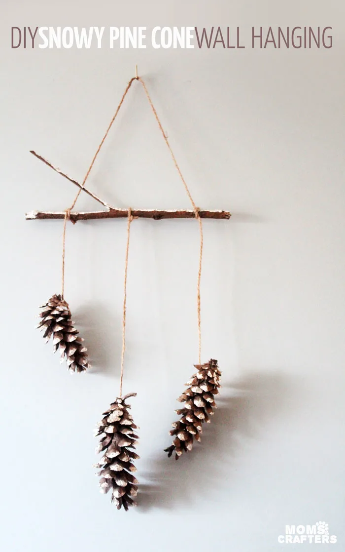 Make this beautiful snowy pine cone wall hanging! Such a pretty and easy winter craft to decorate your home. Plus, how to add a matching aroma to your decor!