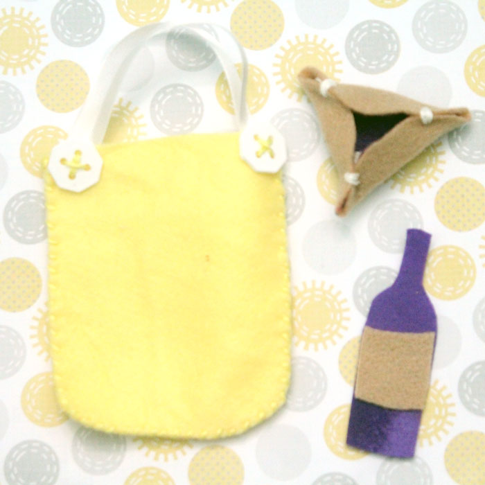 Make an adorable purim play set from felt! This DIY toy for the holiday of Purim includes hamantaschen, a megillah, a food package with "grape juice", and a gragger/noisemaker. It's an adorable DIY toy for toddlers and great for introducing the Jewish holidays to young kids.