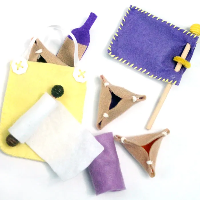 Make an adorable purim play set from felt! This DIY toy for the holiday of Purim includes hamantaschen, a megillah, a food package with "grape juice", and a gragger/noisemaker. It's an adorable DIY toy for toddlers and great for introducing the Jewish holidays to young kids.