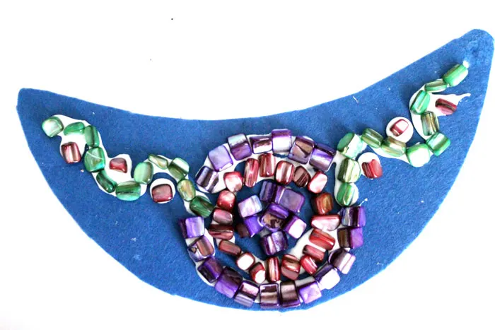 Make a beautiful DIY bib necklace with a pretty mosaic pattern. You can freeform or use symmetrical patterns on this fun jewelry making craft that's perfect for Spring, or any time you want to dress up a plain tee. It's so easy!