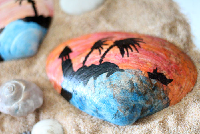 Make a beautiful painted seashell craft that totally fits! The stunning sunset beach scene is so appropriate for shells and makes a great art class prompt too - perfect for some summer fun!