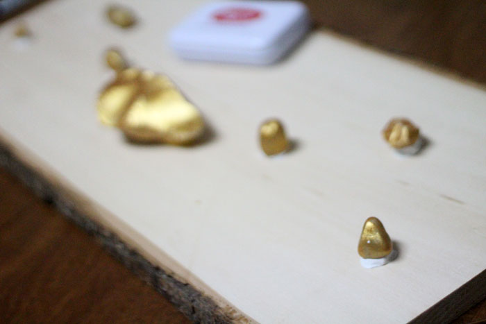 I LOVE how easy it is to make this DIY key and accessory organizer. What a great idea to declutter an entryway. IT will fit a rustic or natural home decor theme, with a touch of metallic gold too. Such a great entry organization idea - and it uses rocks, which are stuck WITHOUT TOOLS - how cool?!