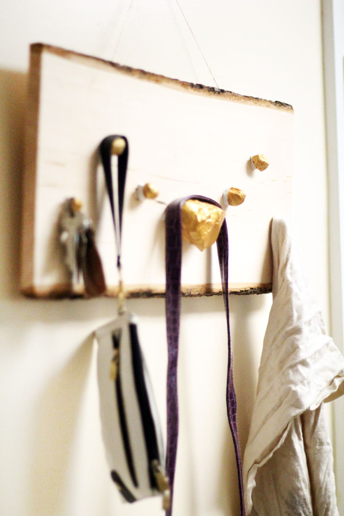 I LOVE how easy it is to make this DIY key and accessory organizer. What a great idea to declutter an entryway. IT will fit a rustic or natural home decor theme, with a touch of metallic gold too. Such a great entry organization idea - and it uses rocks, which are stuck WITHOUT TOOLS - how cool?!