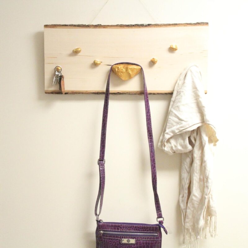 I LOVE how easy it is to make this DIY key and accessory organizer. What a great idea to declutter an entryway. IT will fit a rustic or natural home decor theme, with a touch of metallic gold too. Such a great entry organization idea - and it uses rocks, which are stuck WITHOUT TOOLS - how cool?!