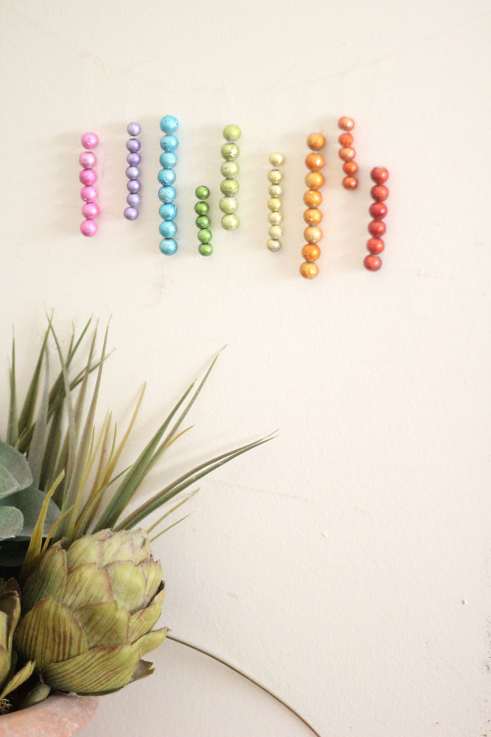 This beautiful DIY garland seems to disappear on the wall, leaving you with the hanging beaded strands! Such a cool effect. Make this easy beaded rainbow garland as a regular home decor staple or as a cool sukkah decoration craft.