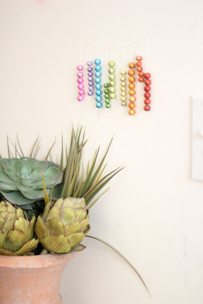 This beautiful DIY garland seems to disappear on the wall, leaving you with the hanging beaded strands! Such a cool effect. Make this easy beaded rainbow garland as a regular home decor staple or as a cool sukkah decoration craft.