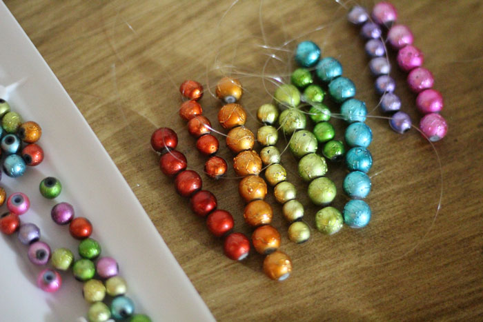 This beautiful DIY garland seems to disappear on the wall, leaving you with the hanging beaded strands! Such a cool effect. Make this easy beaded rainbow garland as a regular home decor staple or as a cool sukkah decoration craft.