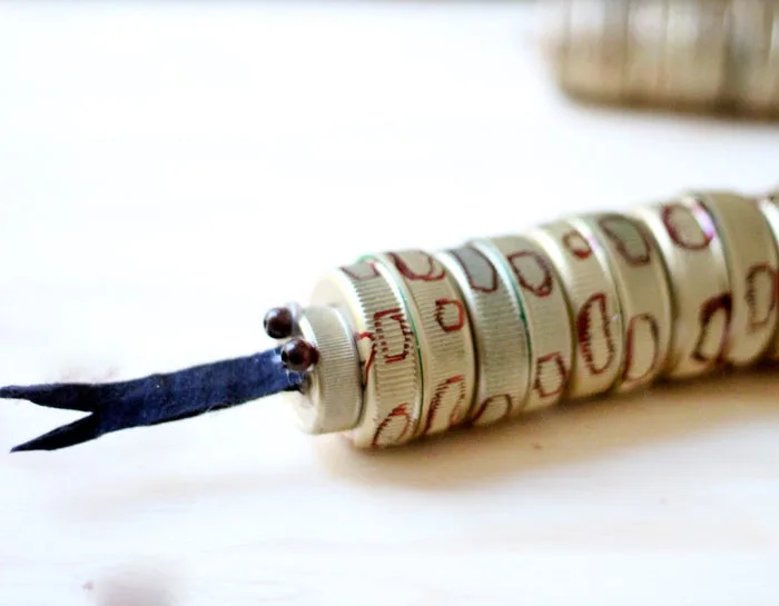 turn your recycling bin into a fun toy! Make a bottle cap rattlesnake craft for your little ones to play with - it actually rattles! This upcycled craft is a fun way to use up your bottle caps and a cute DIY toy idea.