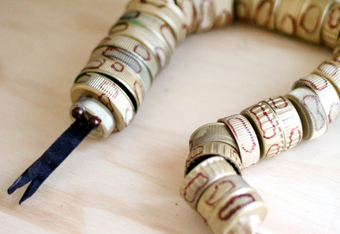 turn your recycling bin into a fun toy! Make a bottle cap rattlesnake craft for your little ones to play with - it actually rattles! This upcycled craft is a fun way to use up your bottle caps and a cute DIY toy idea.