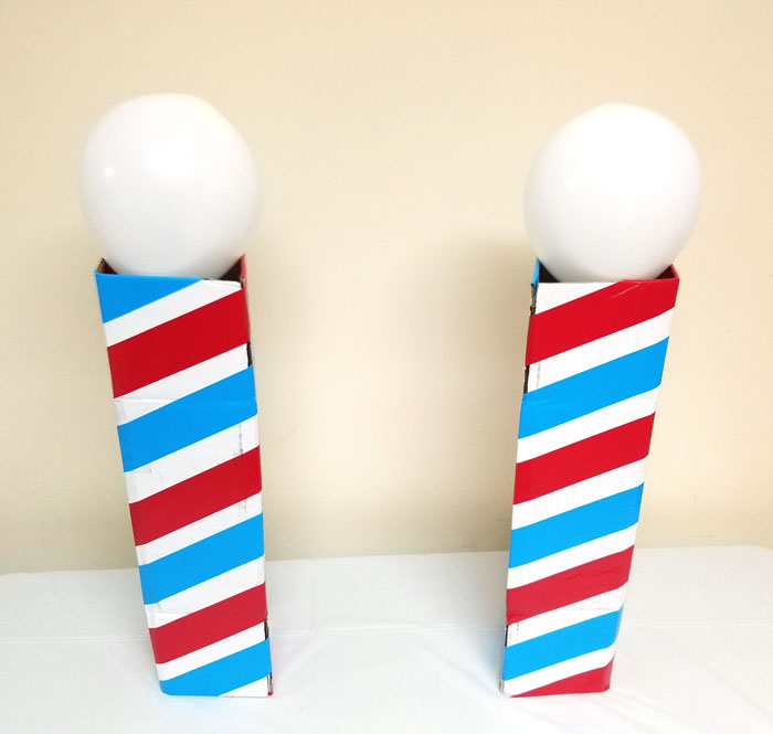 Make this barber shop pole centerpiece for you haircut party! This cool barber shop party decor idea is easy to make, mess-free, and uses recycled materials and is a great, easy upcycled cardboard box craft idea!