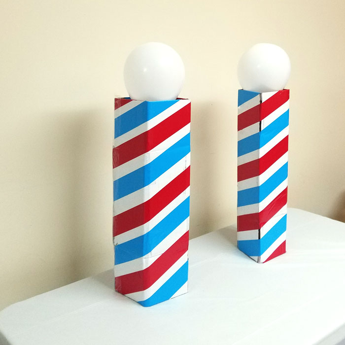 Make this barber shop pole centerpiece for you haircut party! This cool barber shop party decor idea is easy to make, mess-free, and uses recycled materials and is a great, easy upcycled cardboard box craft idea!