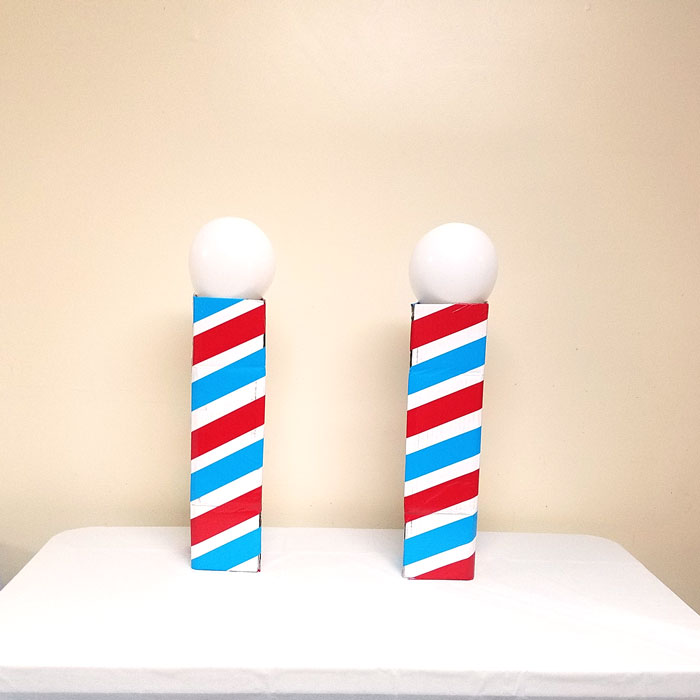 Make this barber shop pole centerpiece for you haircut party! This cool barber shop party decor idea is easy to make, mess-free, and uses recycled materials and is a great, easy upcycled cardboard box craft idea!