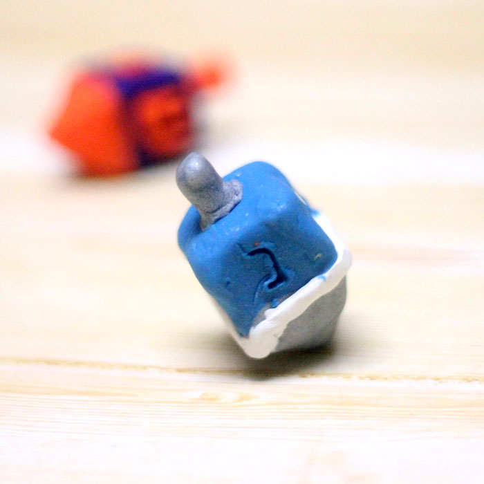 How to make a dreidel out of clay a perfect craft for Hanukkah! You can totally do these as a chanukah party activity since they don't take too long to bake and make a cool gift for kids as well.