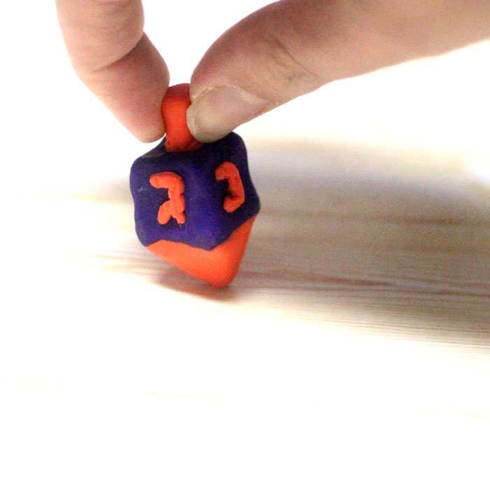 How to make a dreidel out of clay a perfect craft for Hanukkah! You can totally do these as a chanukah party activity since they don't take too long to bake and make a cool gift for kids as well.