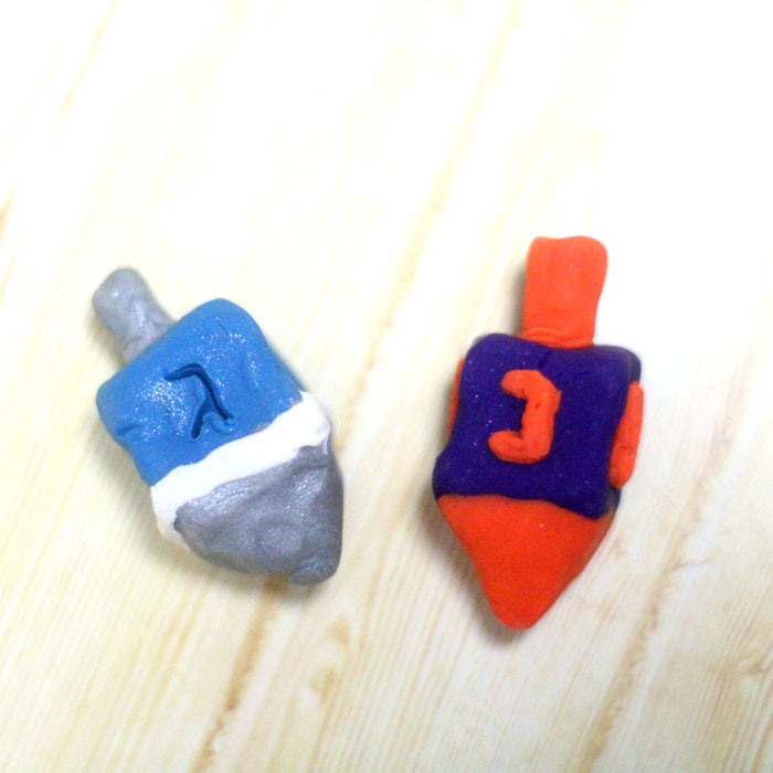 How to make a dreidel out of clay a perfect craft for Hanukkah! You can totally do these as a chanukah party activity since they don't take too long to bake and make a cool gift for kids as well.