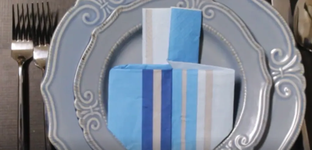 Try this dreidel napkin fold for your Hanukkah celebrations! These DIY dreidel napkins are perfect for your Chanukah party, make great Hanukkah decor and will finish off your tablescape.