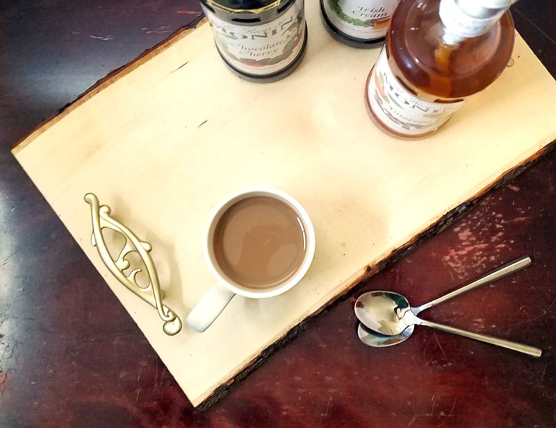 Make this beautiful rustic and easy DIY coffee bar tray - it' super easy! It's great for setting up a coffee bar in the kitchen or a flavoring station at a party or a wedding, and corrals syrups and flavorings in a small space. It has a farmhouse style to it, with a bit of glam added in - just choose the handles to suit your decor!