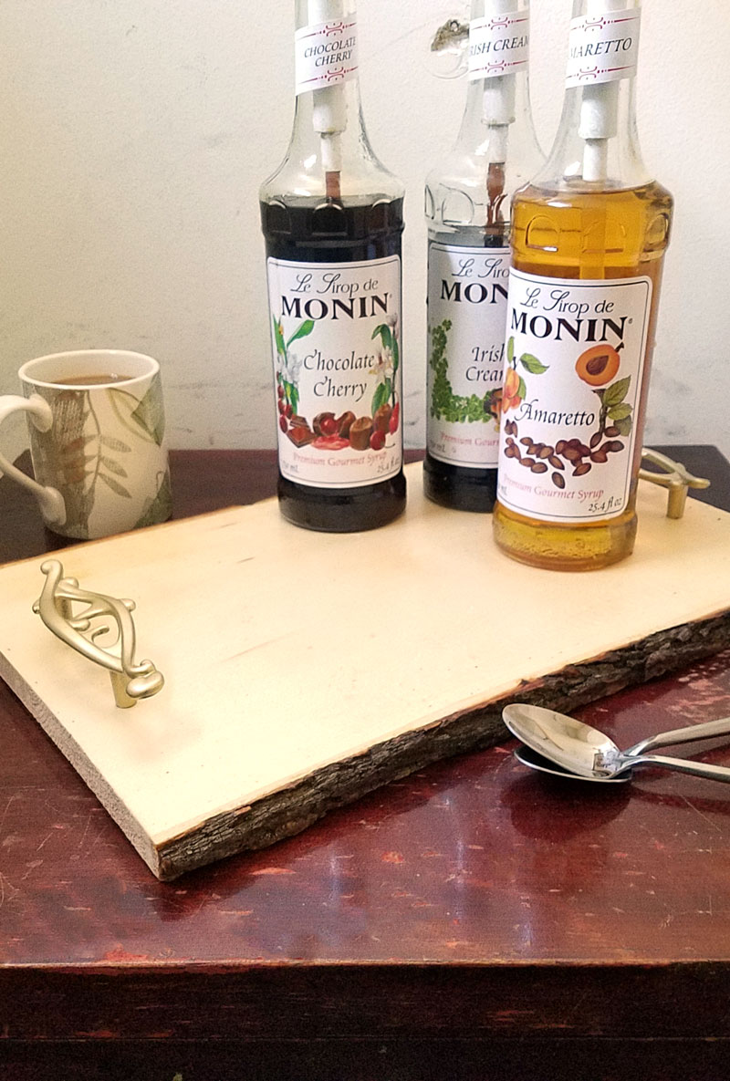 Make this beautiful rustic and easy DIY coffee bar tray - it' super easy! It's great for setting up a coffee bar in the kitchen or a flavoring station at a party or a wedding, and corrals syrups and flavorings in a small space. It has a farmhouse style to it, with a bit of glam added in - just choose the handles to suit your decor!