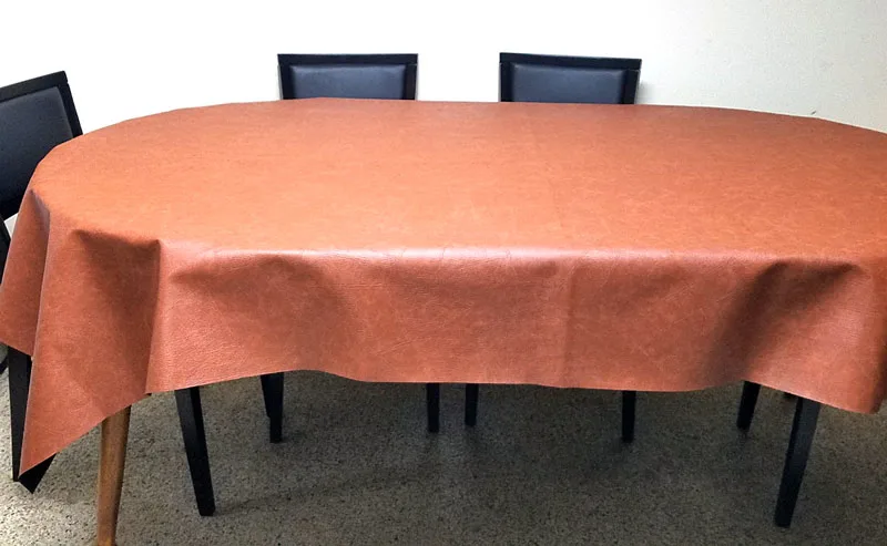 A faux leather table cloth - how brilliant is that?! Make this super easy no sew DIY leatherette tablecloth so your kids don't mess up your good one. It doesn't look tacky like other vinyl table covers, and is a brilliant holiday tablescape idea or kid-friendly decor!