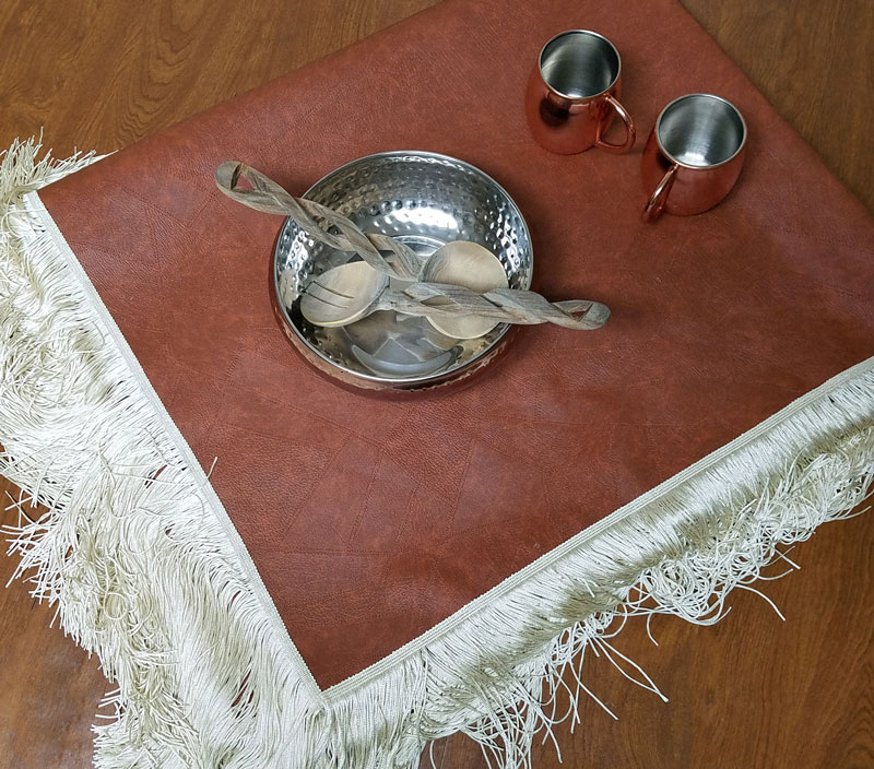 A faux leather table cloth - how brilliant is that?! Make this super easy no sew DIY leatherette tablecloth so your kids don't mess up your good one. It doesn't look tacky like other vinyl table covers, and is a brilliant holiday tablescape idea or kid-friendly decor!