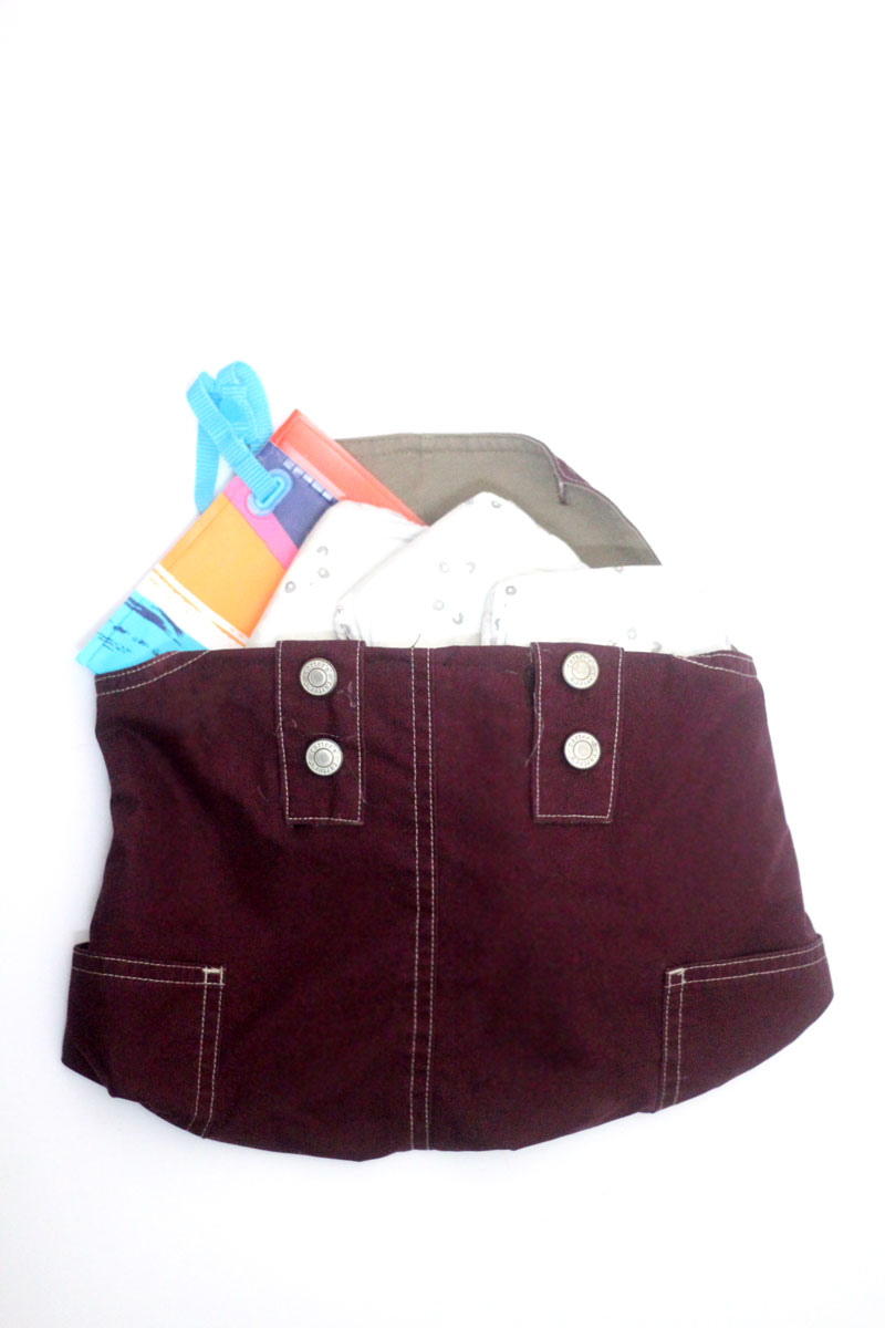 Upcycle old overalls and make this adorable DIY clutch - perfect as a diaper pouch, storage pouch for books, iPad sleeve (or any tablet and device holder) or to contain and protect the library books you're in middle of reading. It's a wounderful eco-friendly recycled beginner sewing crafts and would look just as cute with denim overalls.