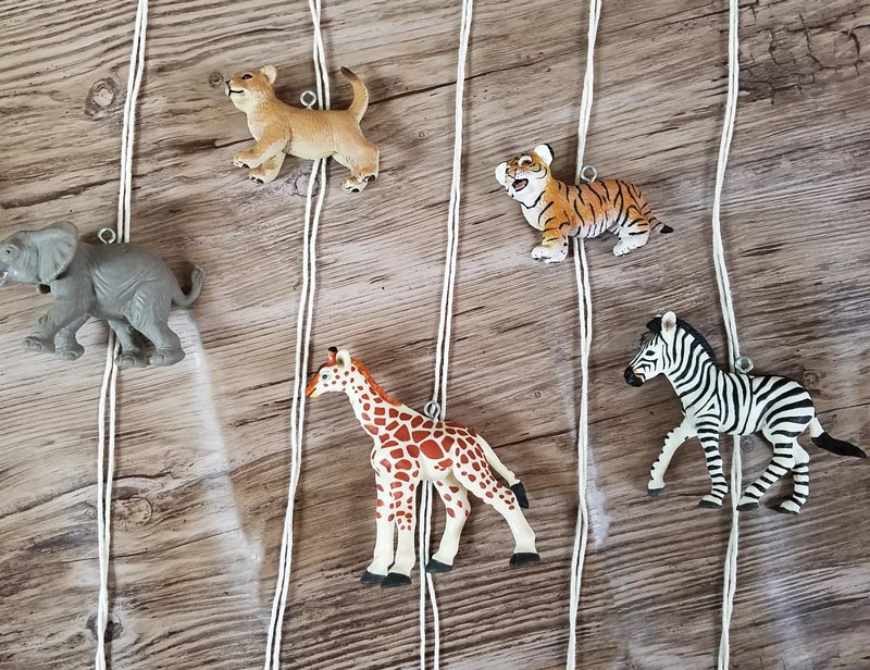 Make an adorable animal wall hanging for the kids room or nursery! Turn toy animals into beautiful playroom decor - and when your'e ready to redecorate, it can be repurposed as a toy! Love this safari animal kids bedroom decor idea - it's such an easy DIY decor craft!