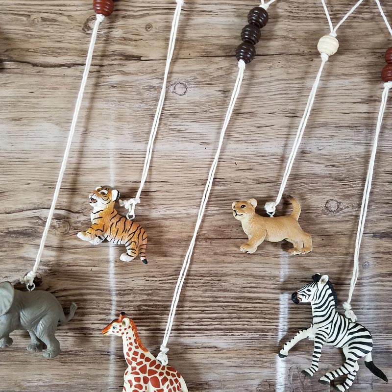 Make an adorable animal wall hanging for the kids room or nursery! Turn toy animals into beautiful playroom decor - and when your'e ready to redecorate, it can be repurposed as a toy! Love this safari animal kids bedroom decor idea - it's such an easy DIY decor craft!