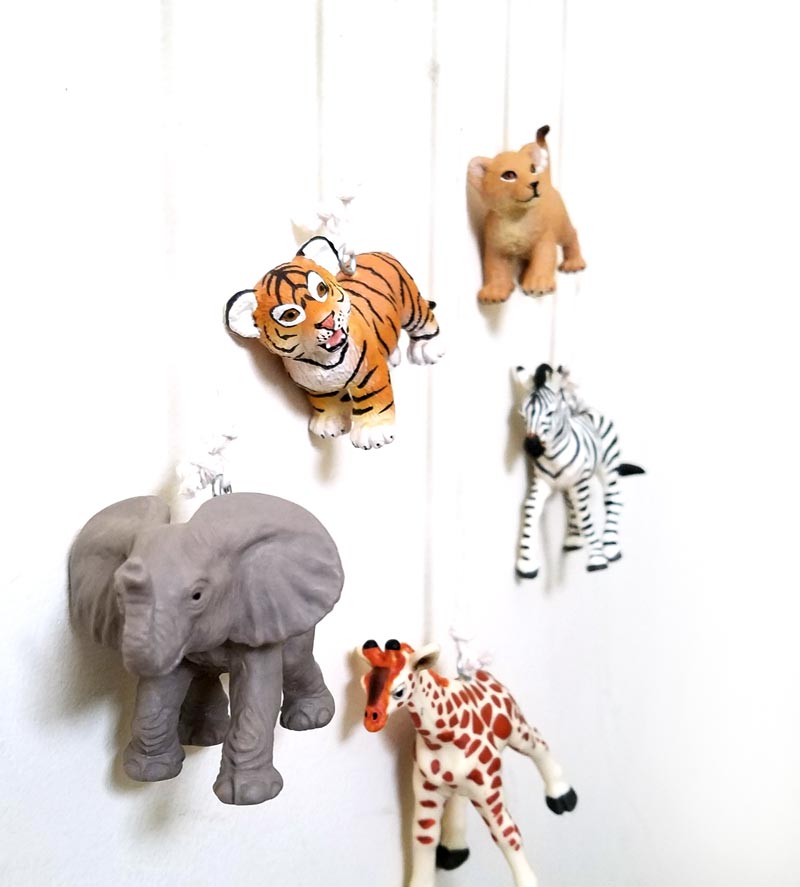 Make an adorable animal wall hanging for the kids room or nursery! Turn toy animals into beautiful playroom decor - and when your'e ready to redecorate, it can be repurposed as a toy! Love this safari animal kids bedroom decor idea - it's such an easy DIY decor craft!