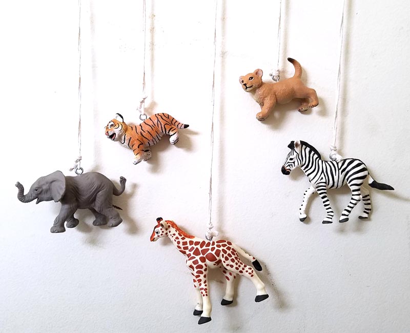 Make an adorable animal wall hanging for the kids room or nursery! Turn toy animals into beautiful playroom decor - and when your'e ready to redecorate, it can be repurposed as a toy! Love this safari animal kids bedroom decor idea - it's such an easy DIY decor craft!