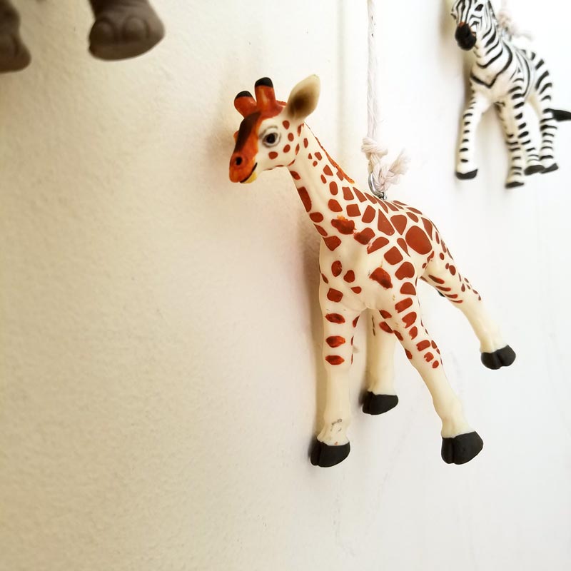 Make an adorable animal wall hanging for the kids room or nursery! Turn toy animals into beautiful playroom decor - and when your'e ready to redecorate, it can be repurposed as a toy! Love this safari animal kids bedroom decor idea - it's such an easy DIY decor craft!