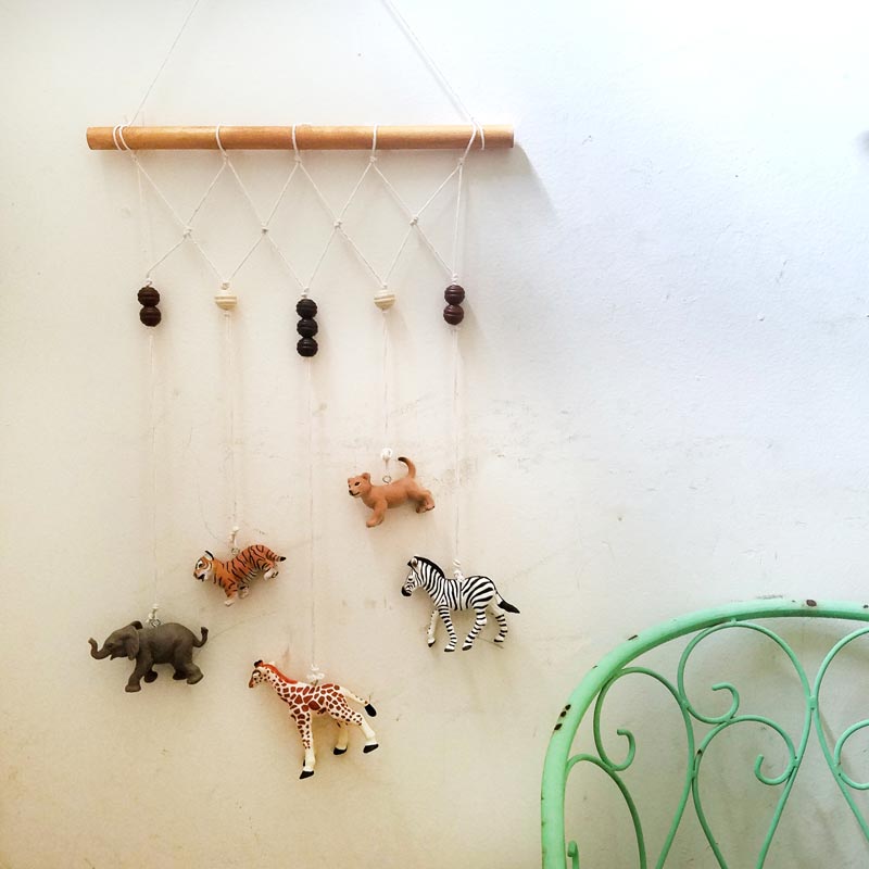 Make an adorable animal wall hanging for the kids room or nursery! Turn toy animals into beautiful playroom decor - and when your'e ready to redecorate, it can be repurposed as a toy! Love this safari animal kids bedroom decor idea - it's such an easy DIY decor craft!