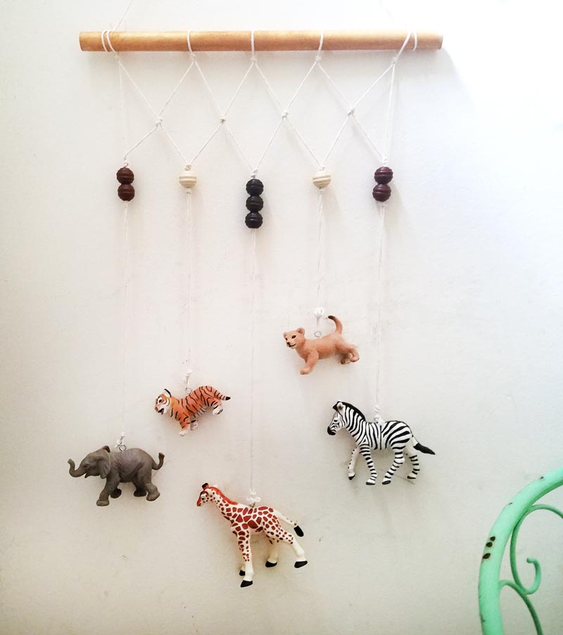 Make an adorable animal wall hanging for the kids room or nursery! Turn toy animals into beautiful playroom decor - and when your'e ready to redecorate, it can be repurposed as a toy! Love this safari animal kids bedroom decor idea - it's such an easy DIY decor craft!