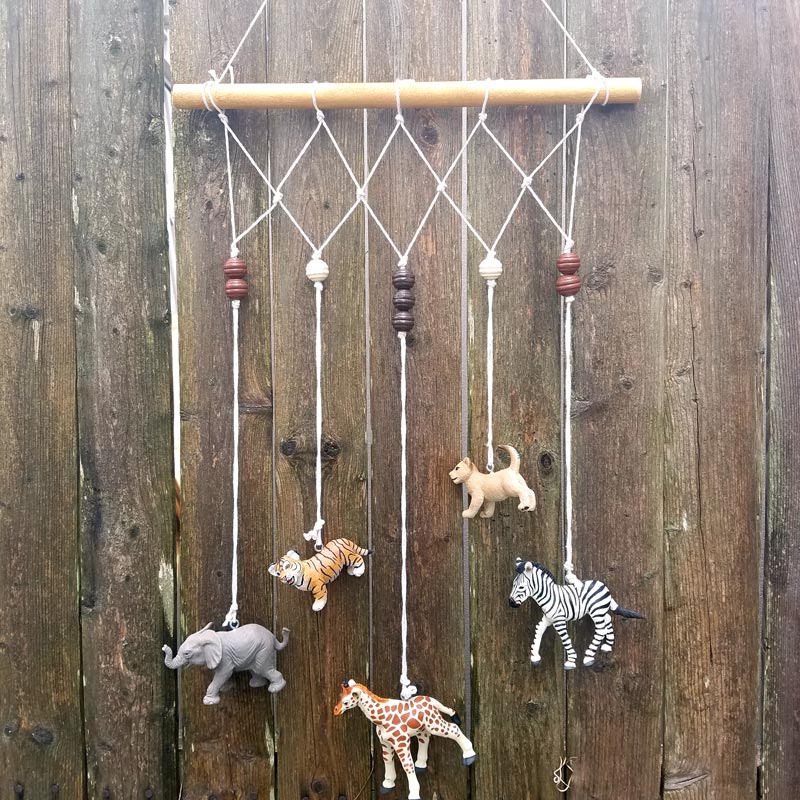 Make an adorable animal wall hanging for the kids room or nursery! Turn toy animals into beautiful playroom decor - and when your'e ready to redecorate, it can be repurposed as a toy! Love this safari animal kids bedroom decor idea - it's such an easy DIY decor craft!