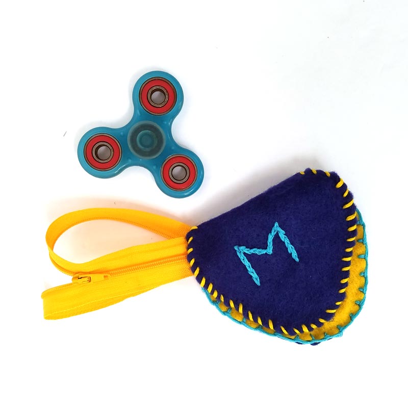 Make this DIY fidget spinner case to protect your fidget toy and keep it a bit farther out of reach of babies! It's an easy beginner felt sewing project that an adult or a child can make, plus it has a built in zipper fidget too! Free template / pattern included.