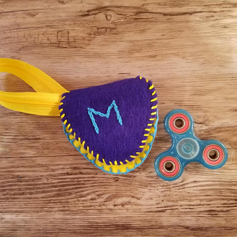 Make this DIY fidget spinner case to protect your fidget toy and keep it a bit farther out of reach of babies! It's an easy beginner felt sewing project that an adult or a child can make, plus it has a built in zipper fidget too! Free template / pattern included.