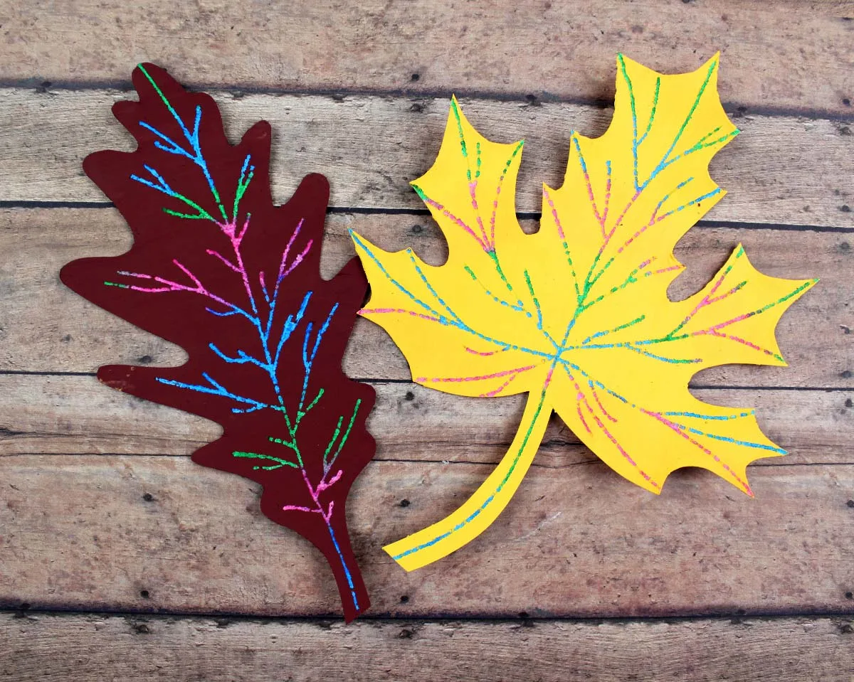 Make this beautiful scratch art fall leaf craft - a beautiful and easy autumn paper craft for kids! Includes a free printable template.