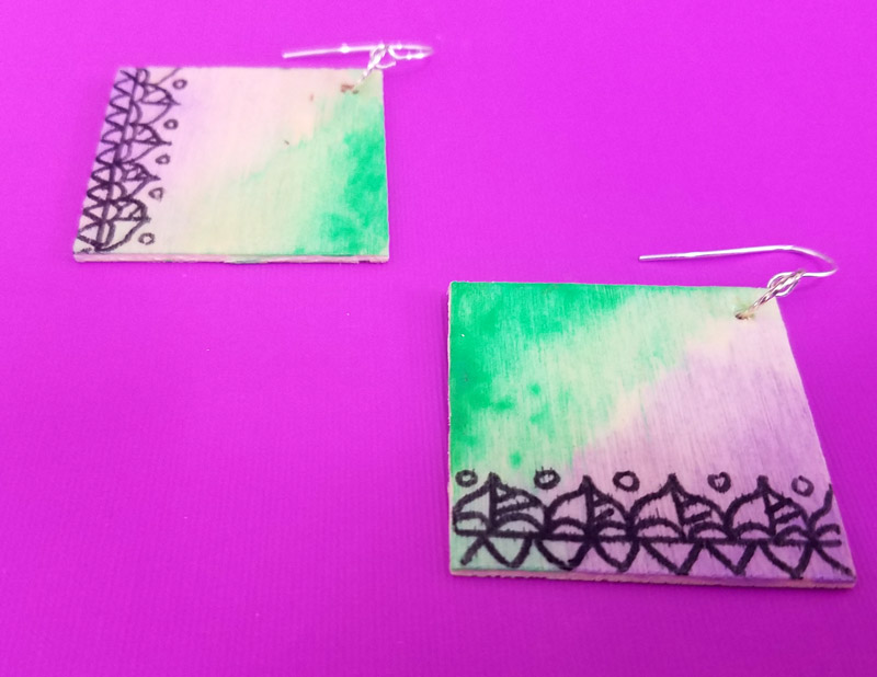 Make these stunning DIY earrings with a watercolor finish and some cool doodles! You'll love this beginner jewelry making project for teens and tweens to enjoy.