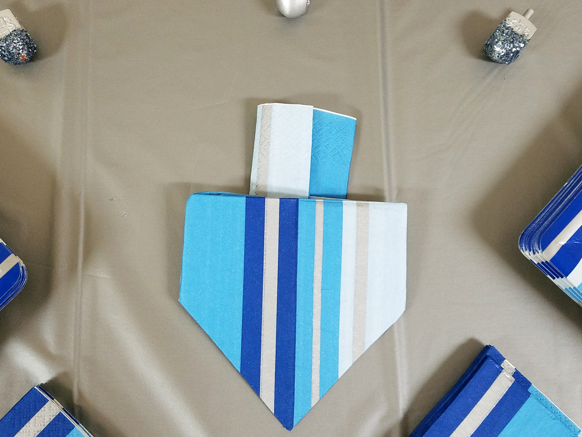 I love this dreidel napkin fold tutorial - what a great idea for a Hanukkah tablescape? I love this decoration for a chanukah party - I set my table like this too. #Hanukkah #chanukah