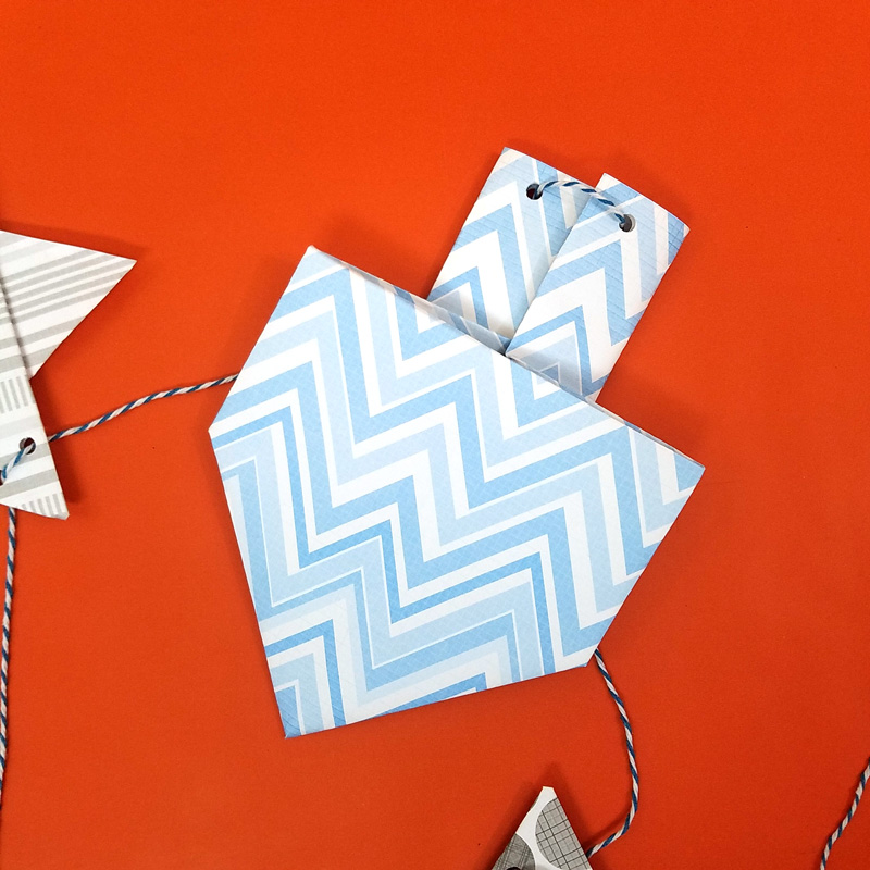 Make a fun origami Hanukkah garland featuring folded paper dreidels and star of david. This simple Chanukah craft for kids teens and adults is a perfect way to update your Hanukkah decor.