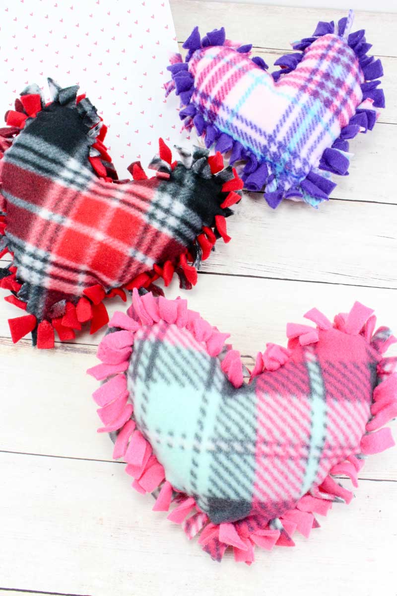 These valentine pillows are so easy to make! They use the classic summer camp fleece tie pillows method and are the perfect Valentine's Day crafts for tweens and big kids. #tweens #teencrafts #valentinesday