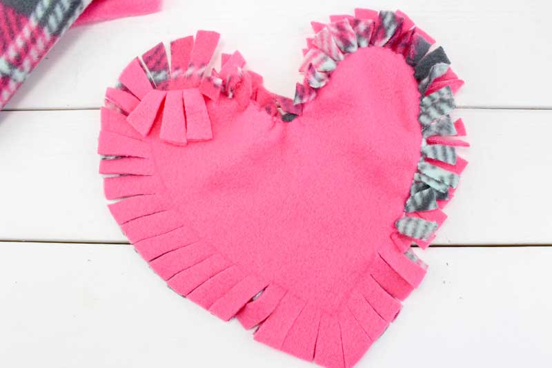 These valentine pillows are so easy to make! They use the classic summer camp fleece tie pillows method and are the perfect Valentine's Day crafts for tweens and big kids. #tweens #teencrafts #valentinesday