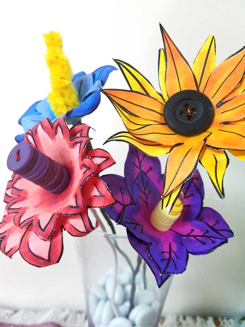 These paper flower templates are too cute for words! What an adorable Spring craft for tweens, teens, or grown-ups! This papercraft is so versatile - use it to set a Spring table, as napkin rings, or put these DIY flowers in a vase. These paper flowers can be made by coloring them in, or using scrapbook paper scraps. #papercraft #spring #freeprintable