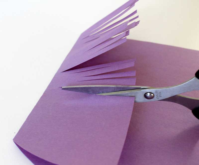 Step 5. Make cuts in the construction paper flap to create hair in the bangs. You can allow your child to do this part too!