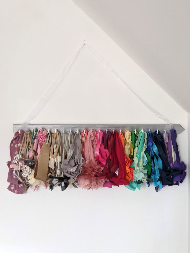 Forward facing view of DIY baby headband holder with headbands arranged in a rainbow